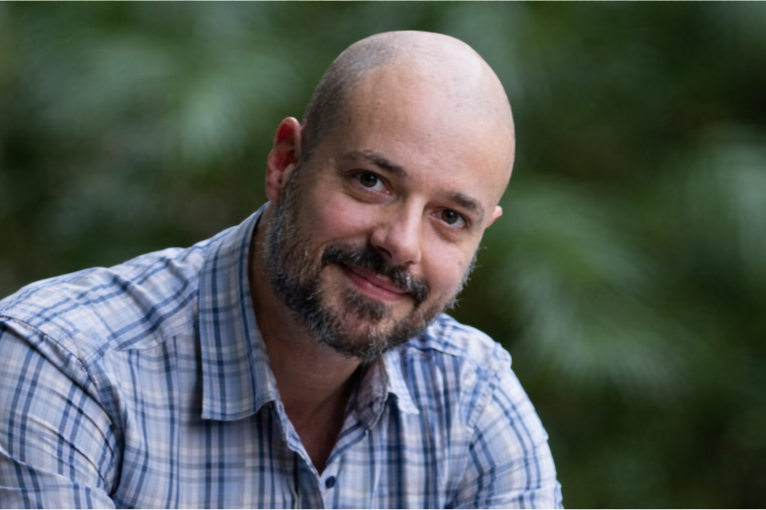 Homem de barba sorrindo ao ar livre