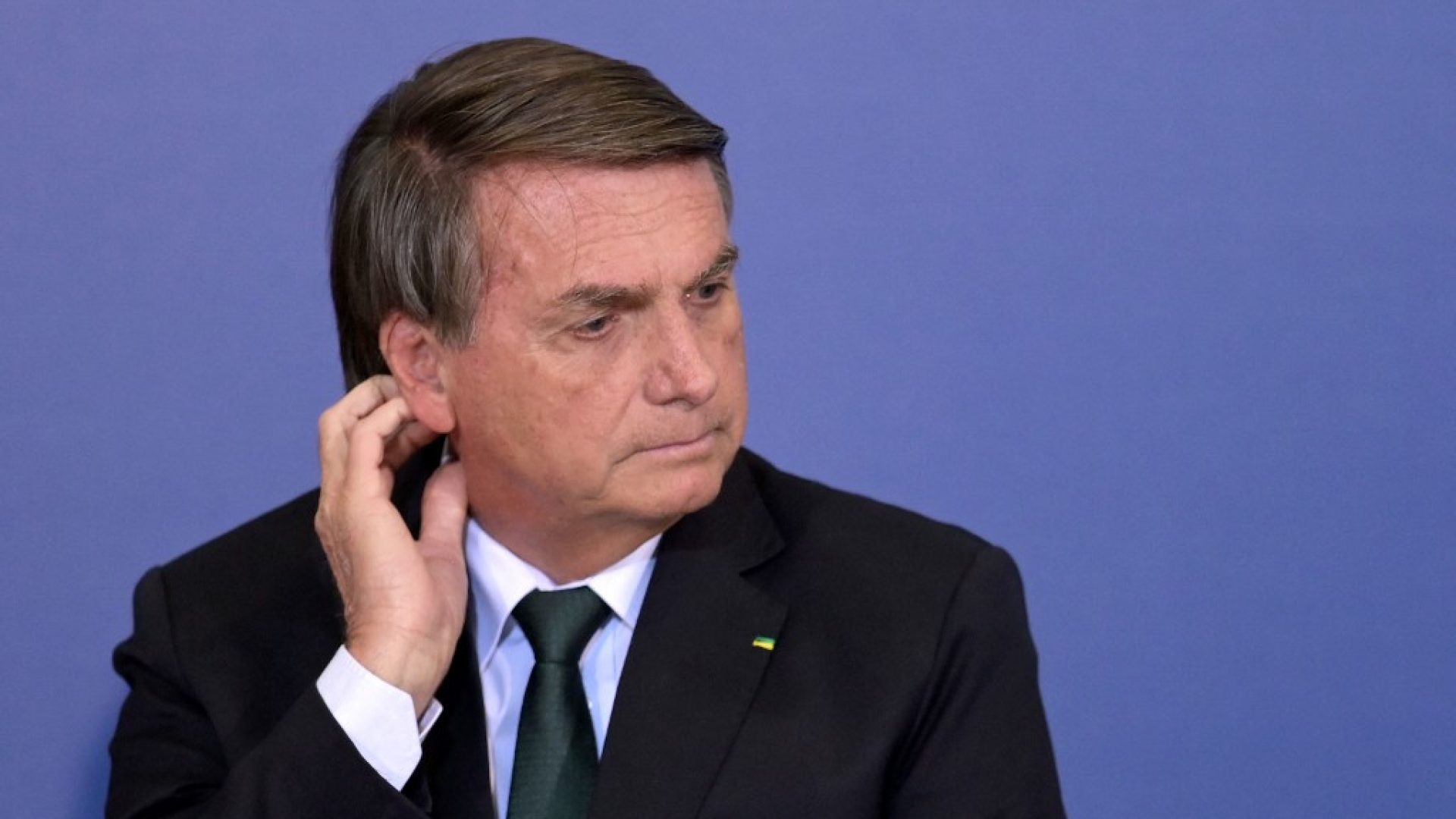 Brazilian President Jair Bolsonaro gestures during the signing of an agreement with Google to facilitate access to free tools to strengthen the educational network across the country, at Planalto Palace in Brasilia on June 20, 2022. - Amid the crisis caused by rising fuel prices, Bolsonaro threatened to encourage the opening of commission in Congress to investigate the profits of Petrobras, a mixed-capital oil company under government control. (Photo by EVARISTO SA / AFP)